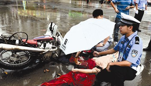 南充两摩托车对撞 交警为伤者撑伞挡雨