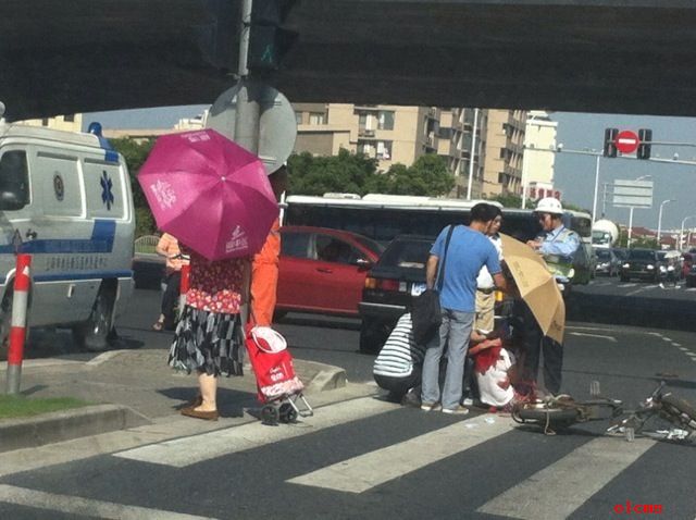 路人轮流帮车祸伤者撑伞遮阳